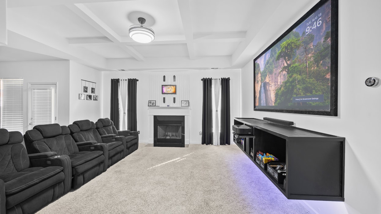 Full room home theater setup with wall-mounted TV and surround sound installation in Gwinnett County